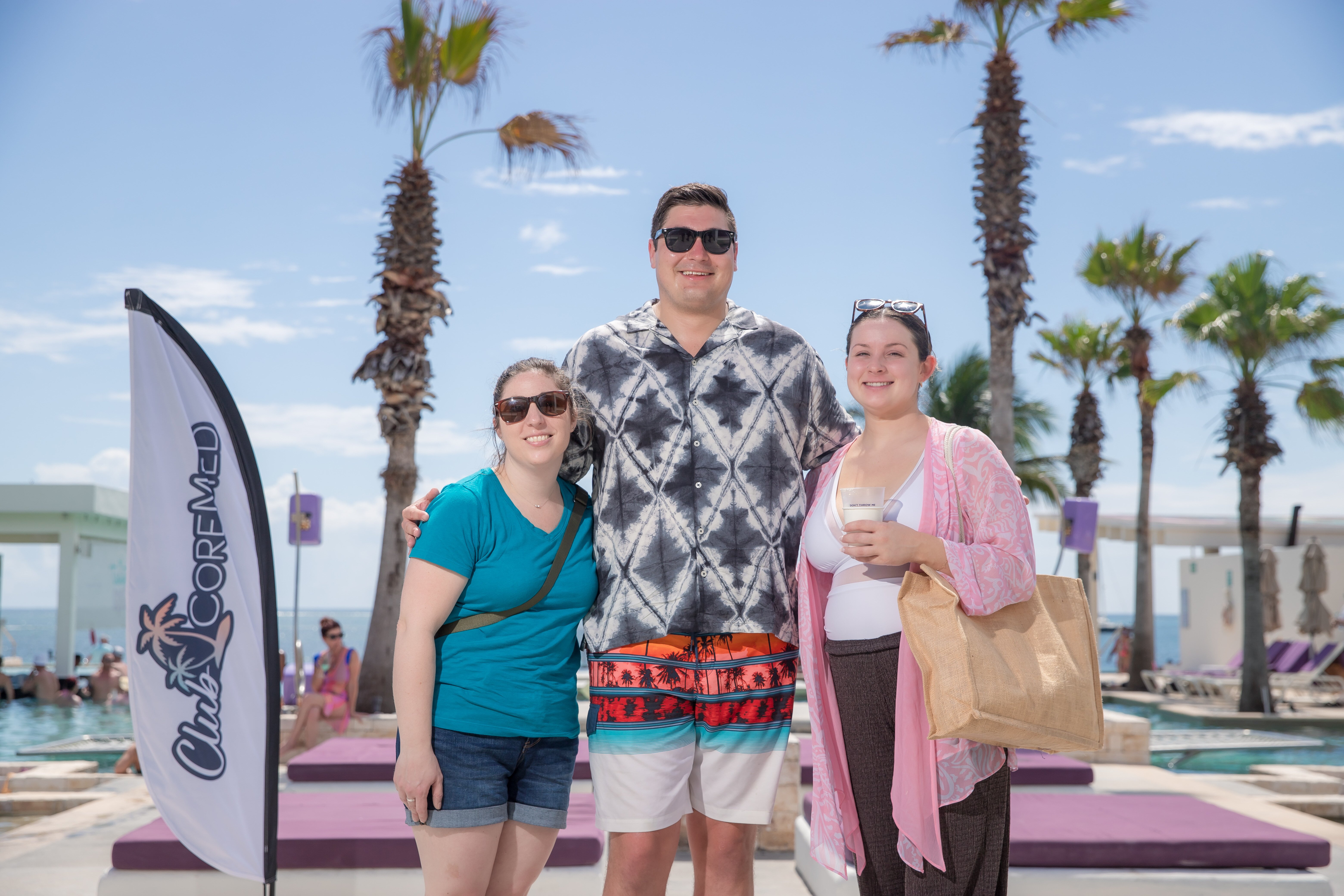 Three individuals posing for a photo at the resort pool. 